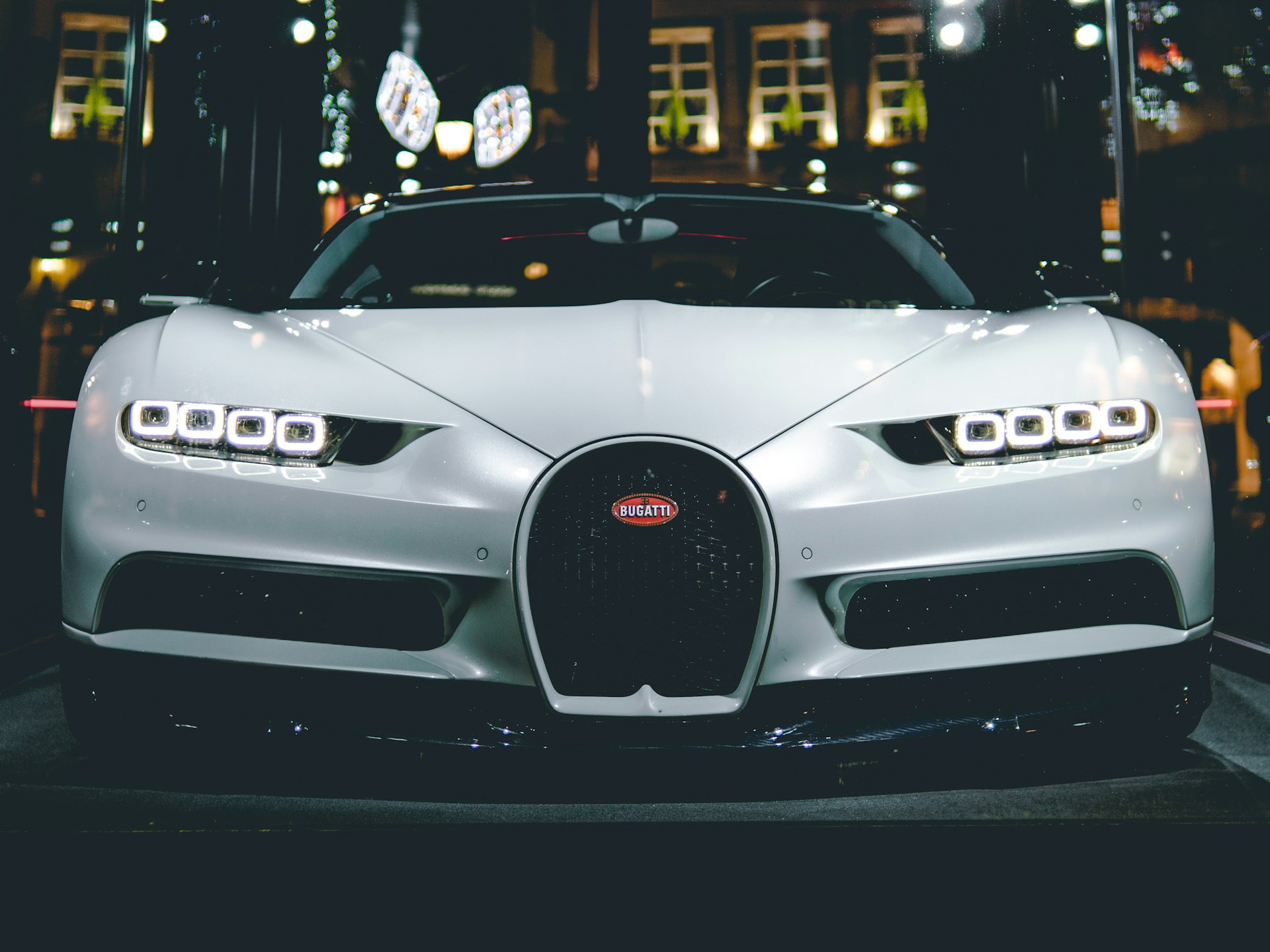 Hypercar bianca fotografata di notte in un contesto urbano europeo