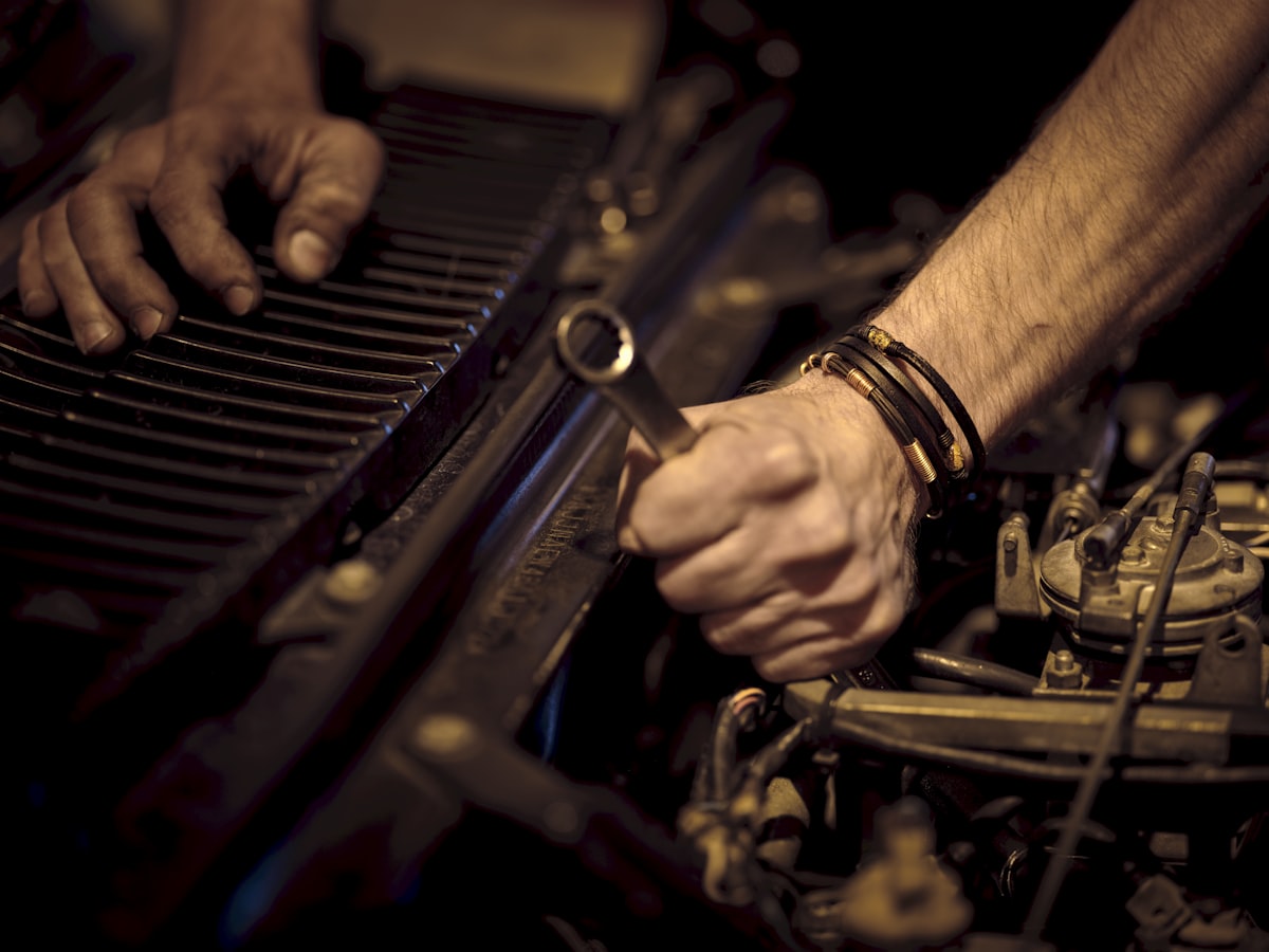 Mani di un meccanico al lavoro sul motore